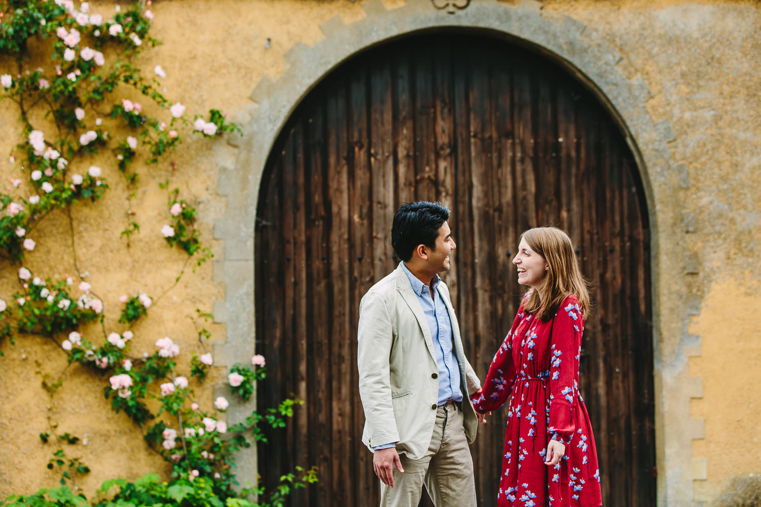 Engaged couple in Ely captured by an Ely Photographer. Couple in front of brown gates.