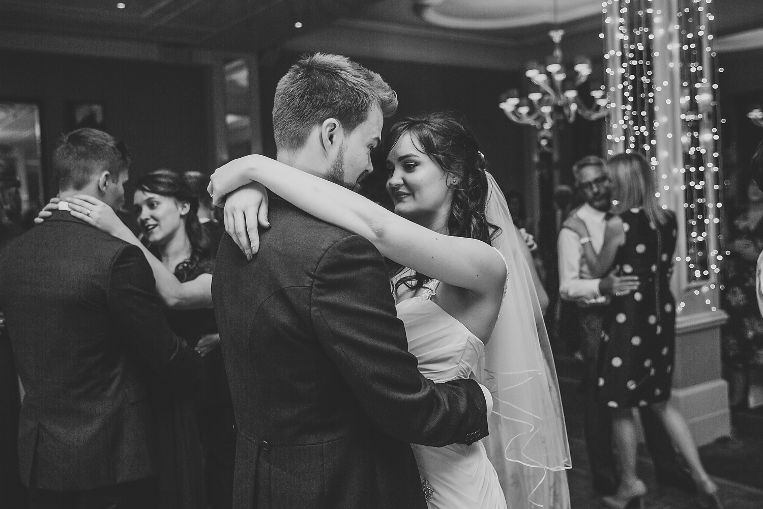 Black and white wedding photos of bride and groom dancing on the dance floor in a hotel.