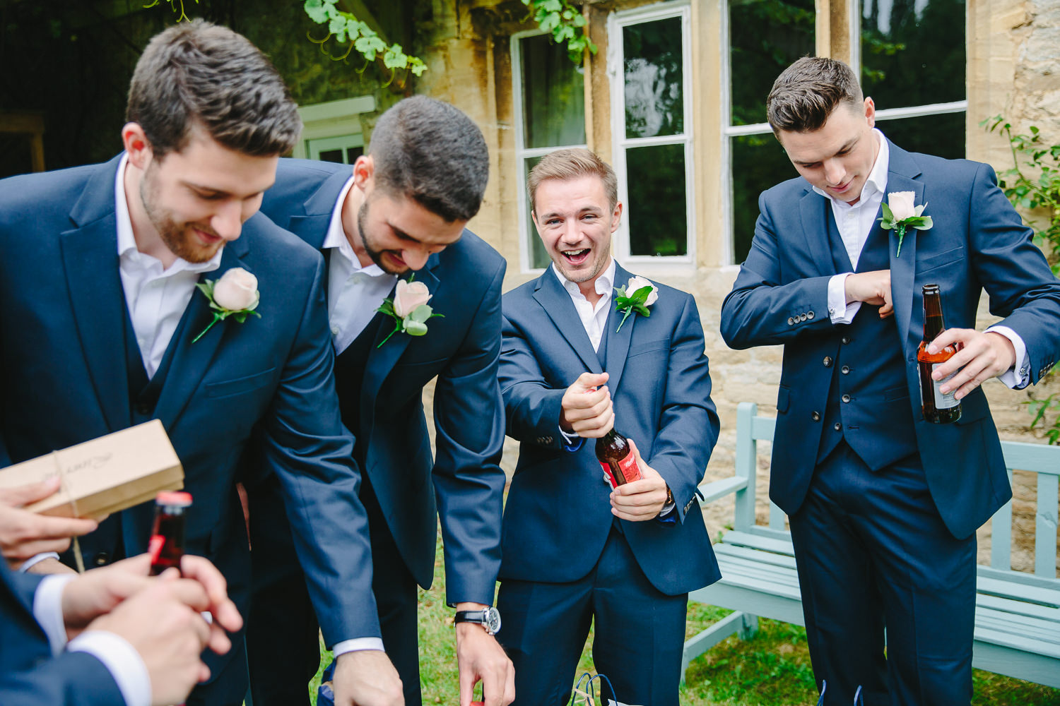 A group of groomsmen opening beer.