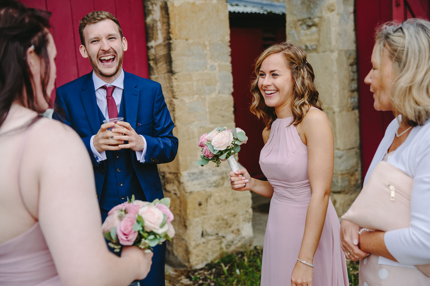 Bridesmaids and guests laughing during a wedding reception.