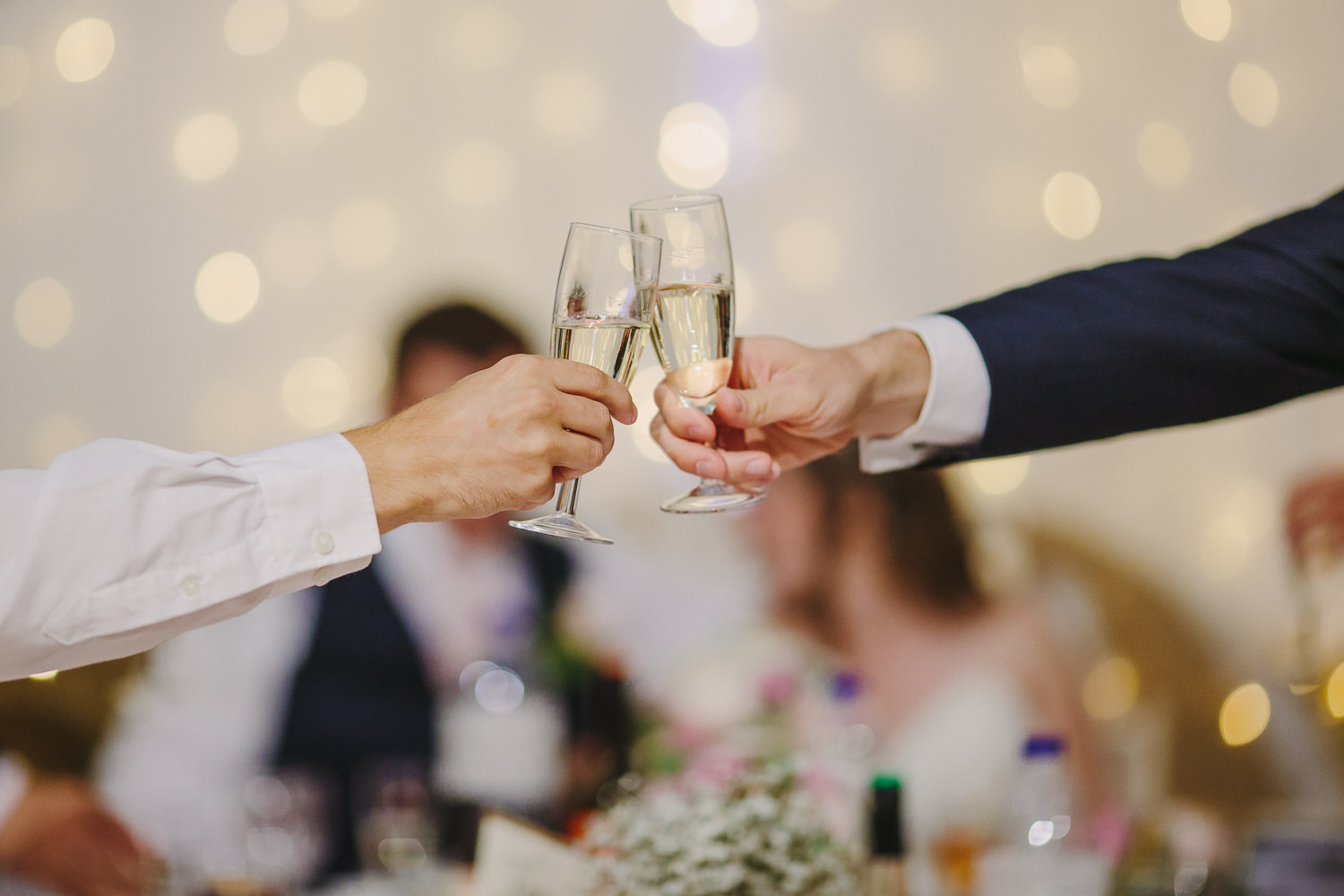 Champagne glasses clinking during a wedding reception.