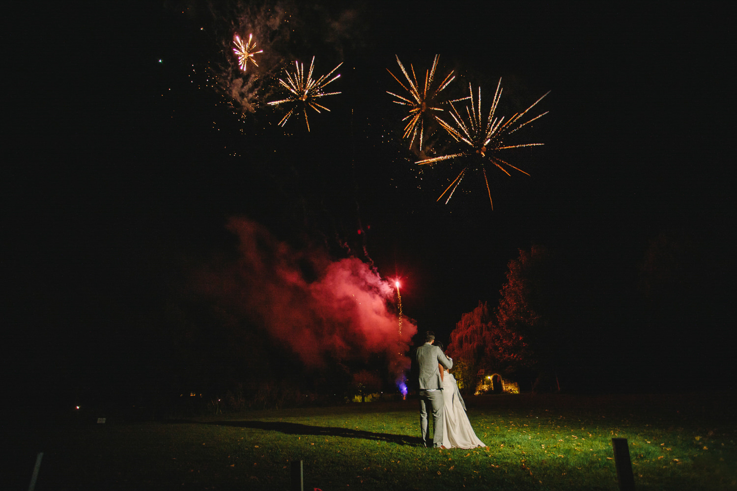 Bride and groom in front of fireoworks