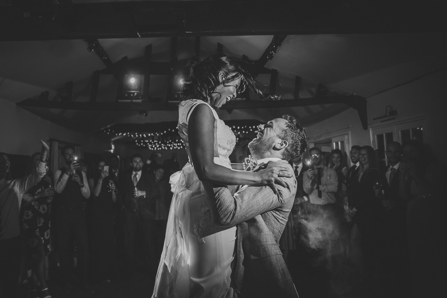 Groom lifting bride on the dance floor.