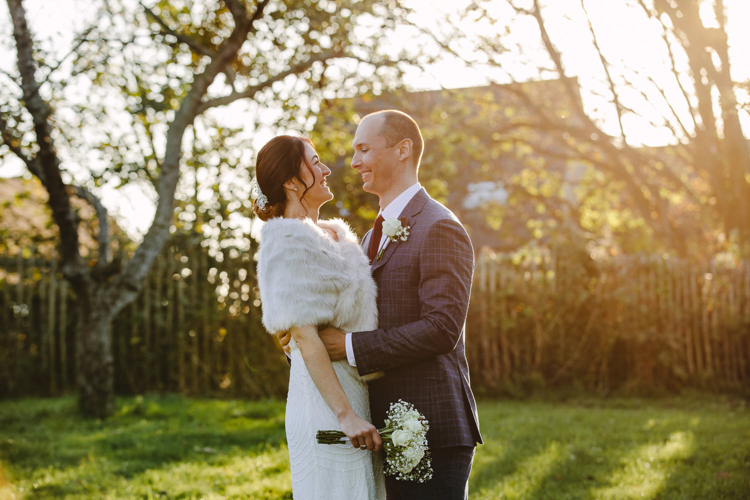 Bride and groom smiling at each other, evening sunshine