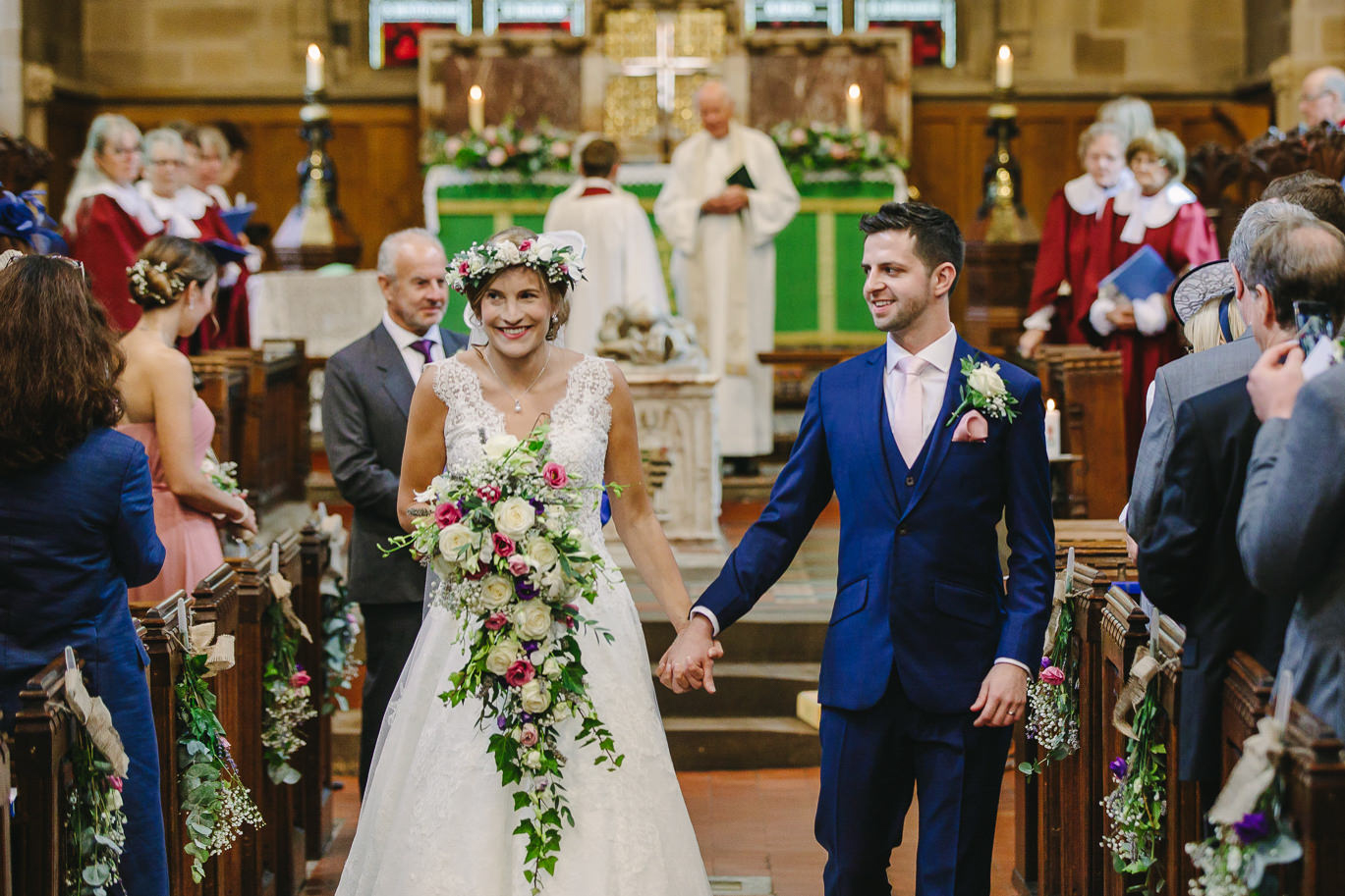 Bride and groom walking down aisle, church, wedding guests