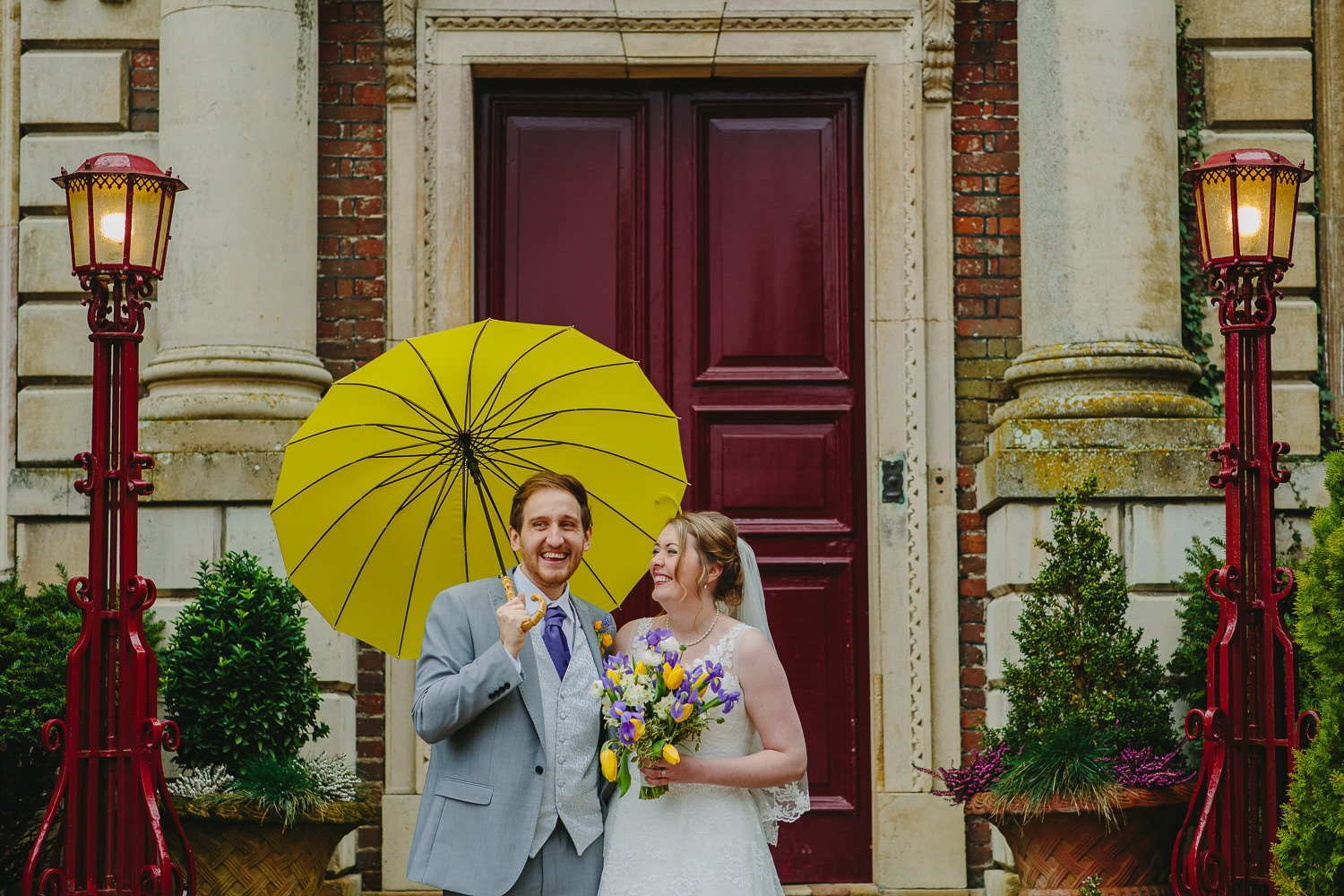 Bride and groom, yellow umbrella and red door