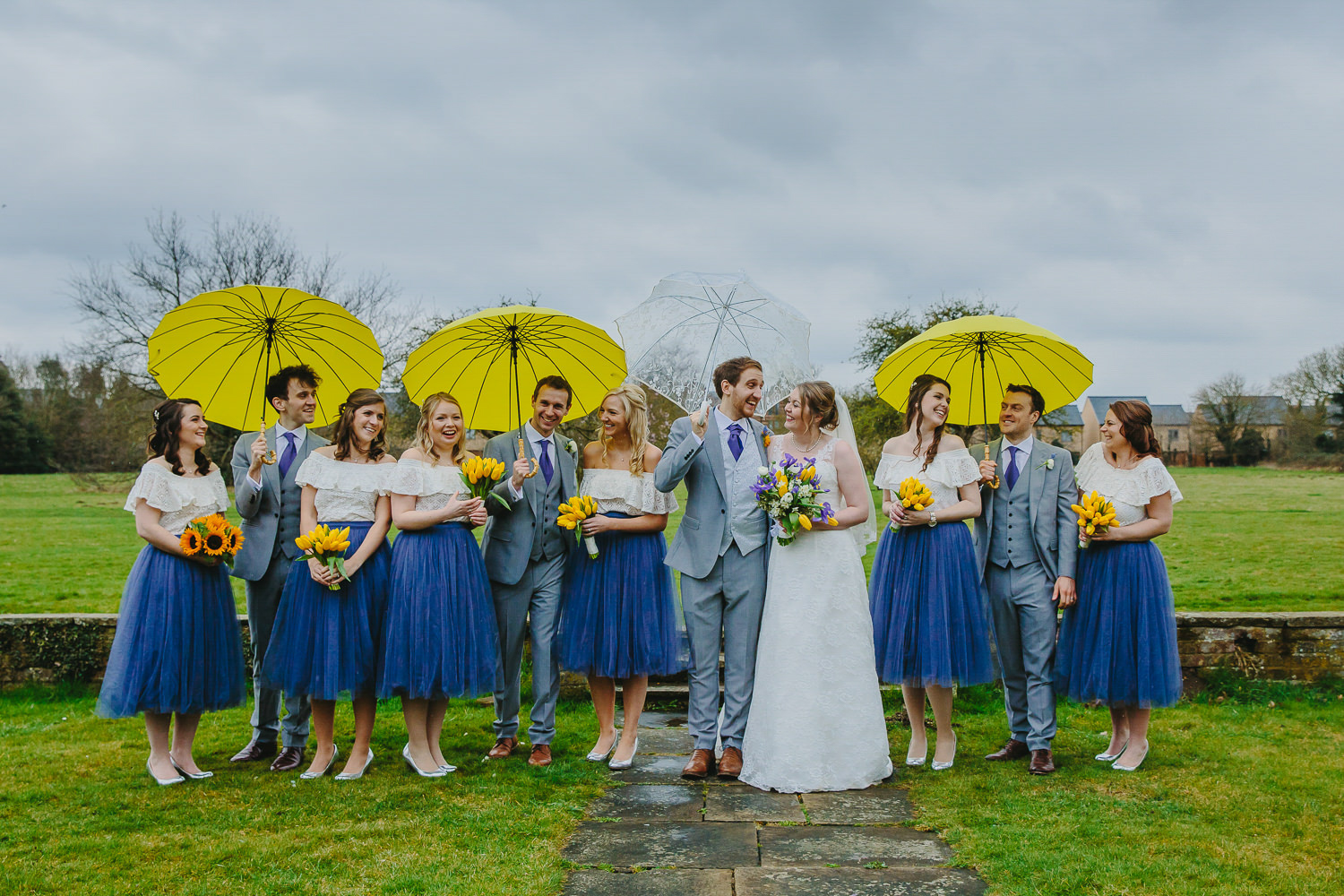 Bride, groom, bridesmaids and ushers with yellow umbrellas