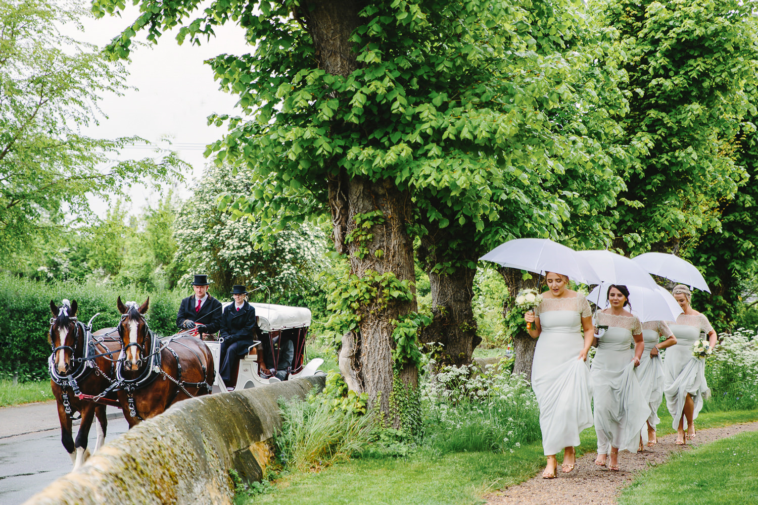 Bridesmaids walking besides horse and carriage