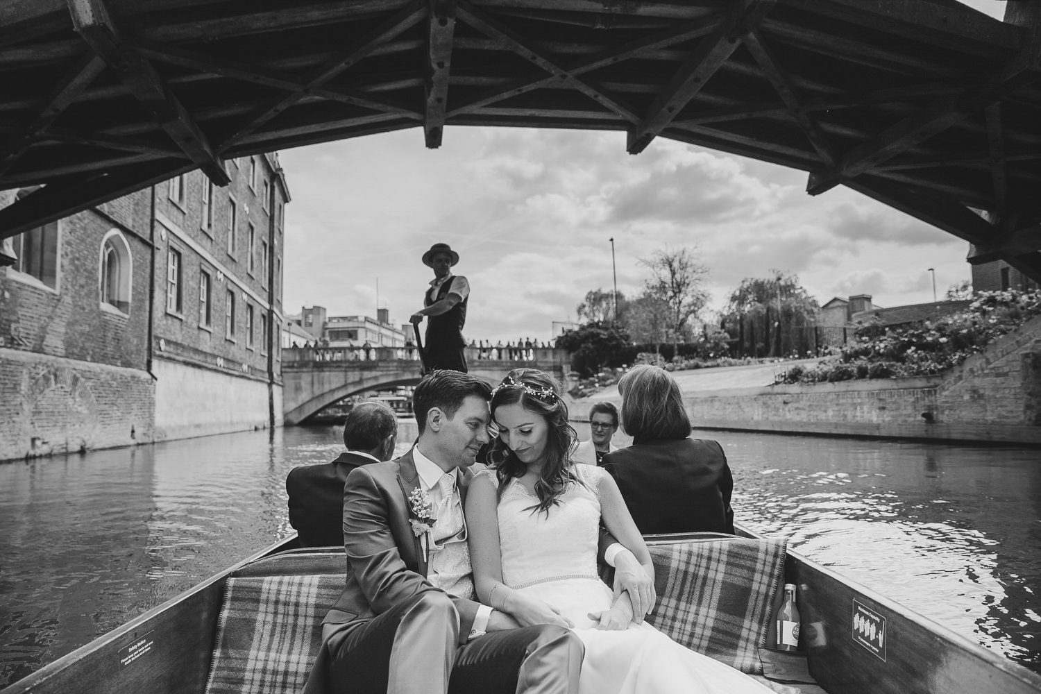 Bride and groom on punt boat going under a bridge