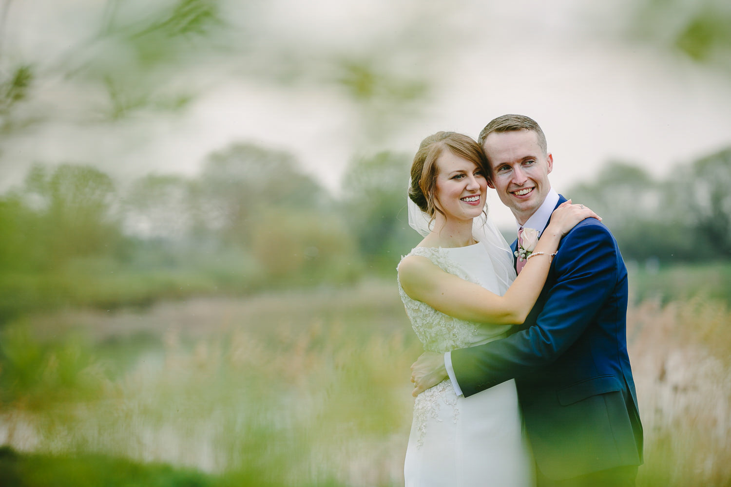 Bride and groom portrait outdoors by a lake