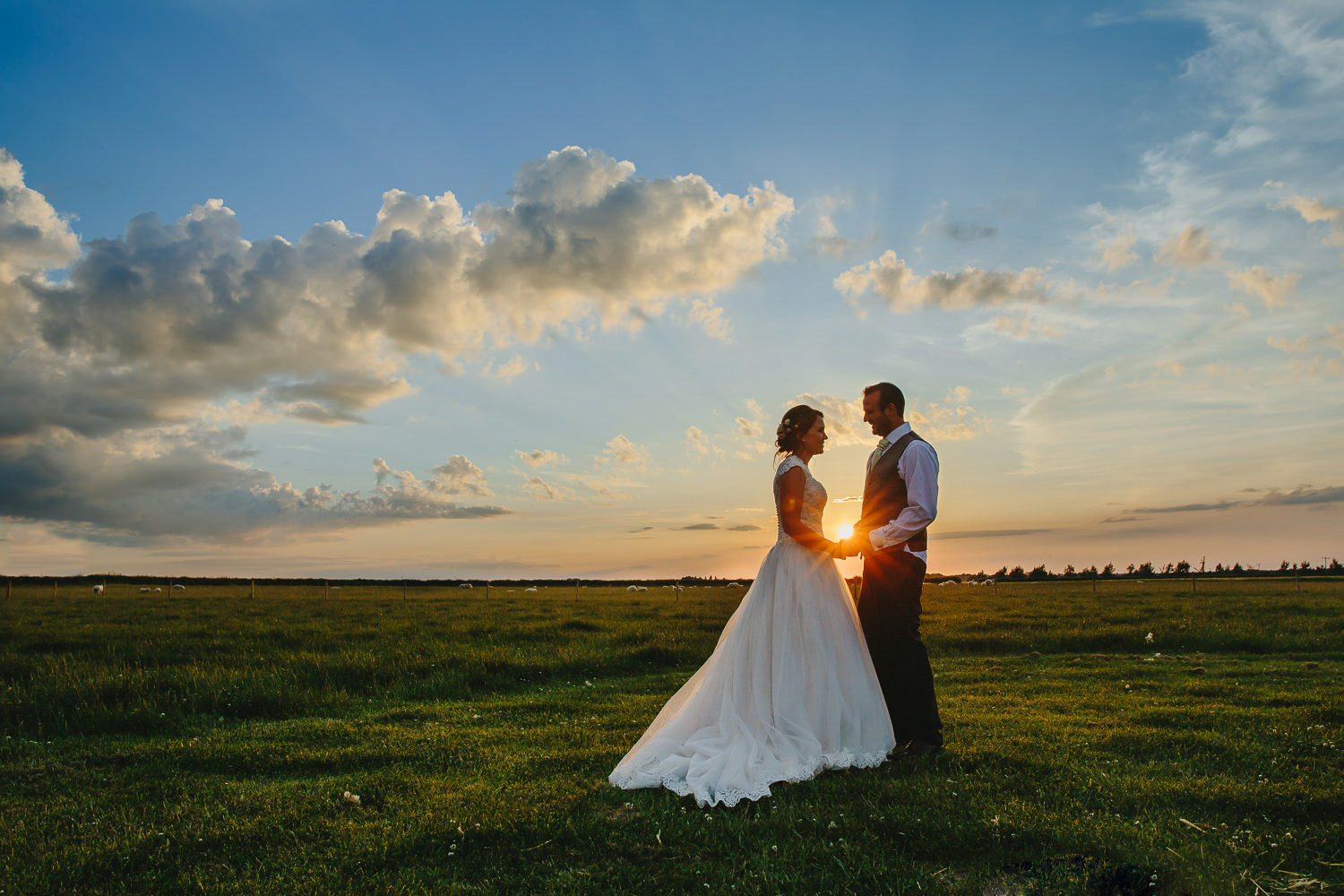 Bride and groom in front of a sunset