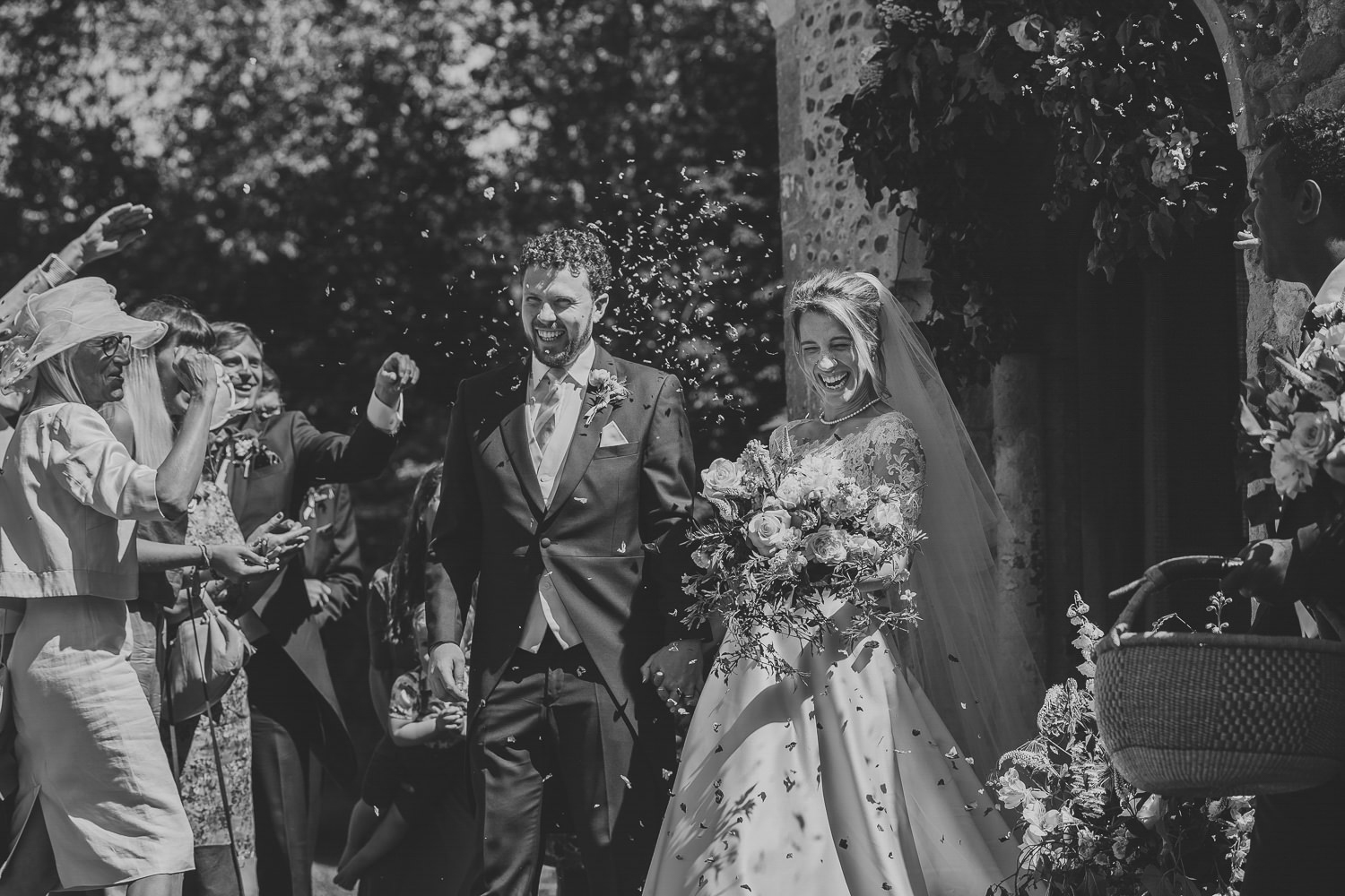 Bride and groom walking through confetti in the sunshine