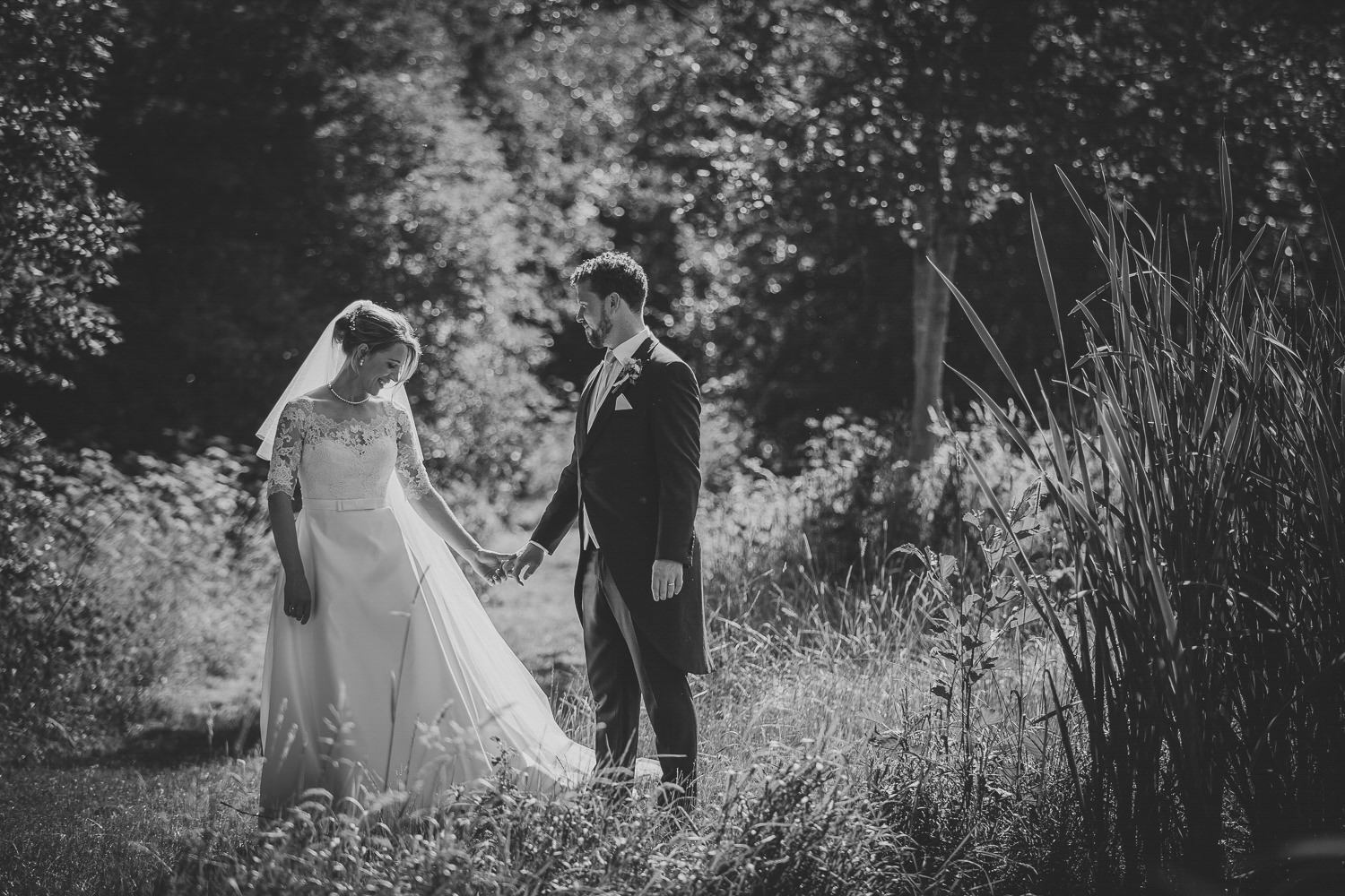 Bride and groom in meadow, sunshine, black and white