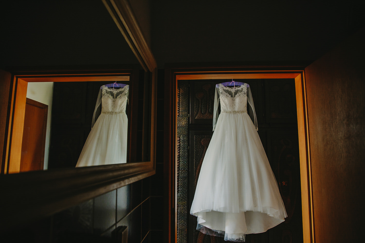 Wedding dress hanging on a wardrobe, reflection in mirror