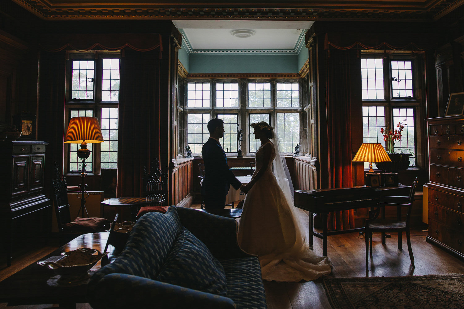 Bride and groom standing in a drawing room of a stately home.