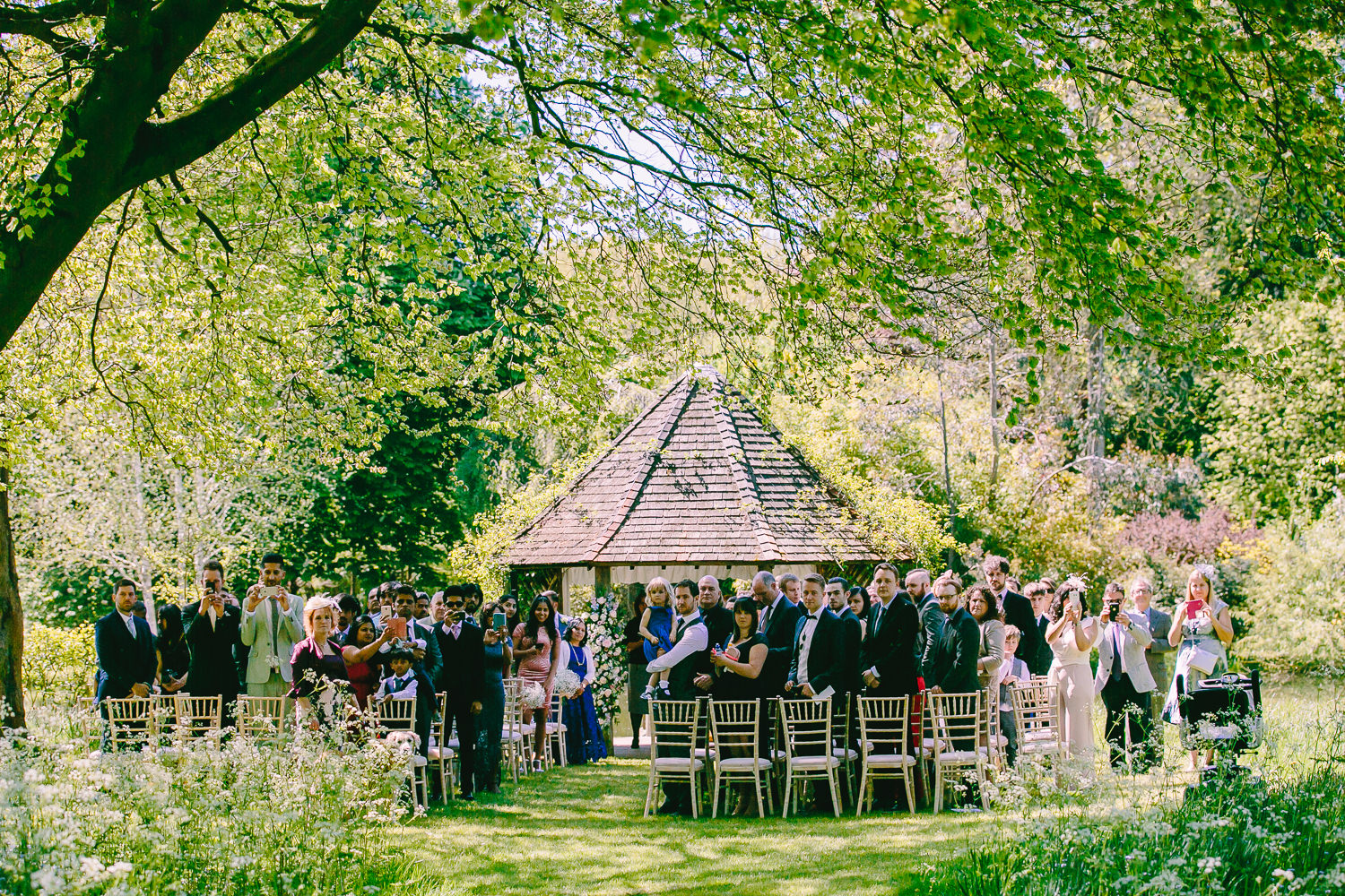 Wedding guests at an outdoor wedding ceremony at Chippenham park