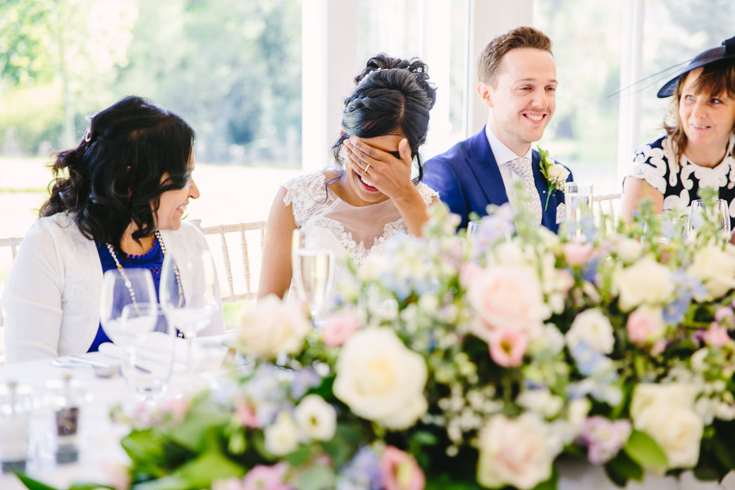 Bride looking embarrassed during wedding speeches