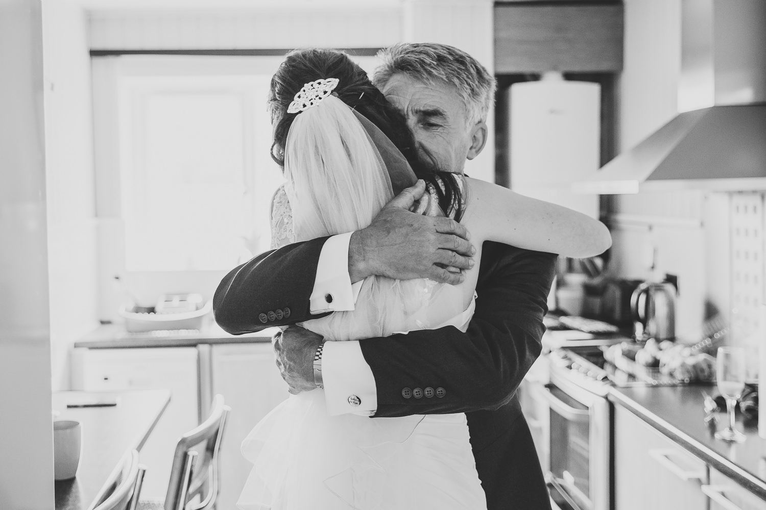 Black and white wedding photo of father hugging his daughter on her wedding day
