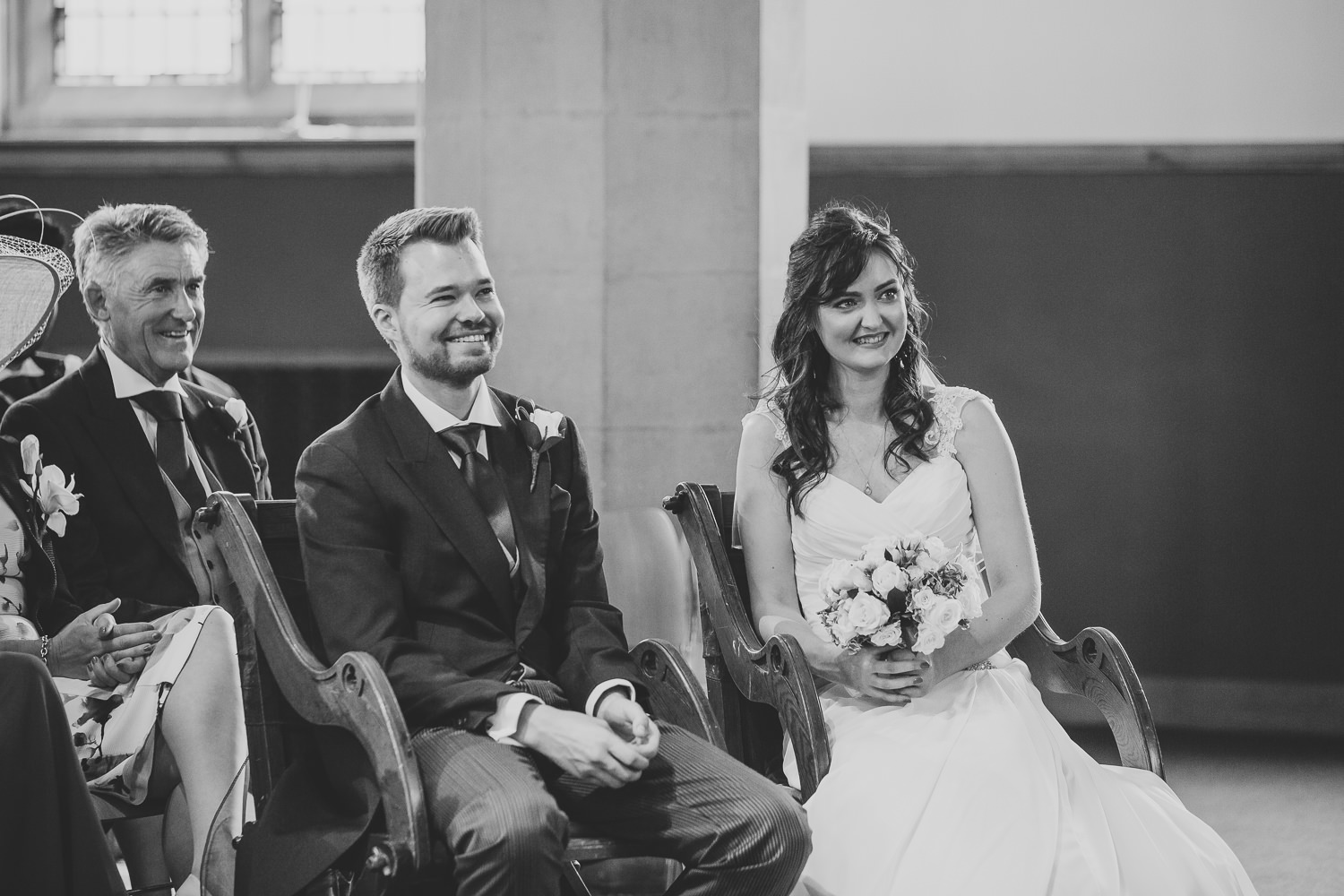 Black and white photo of bride and groom looking happy during the wedding ceremony