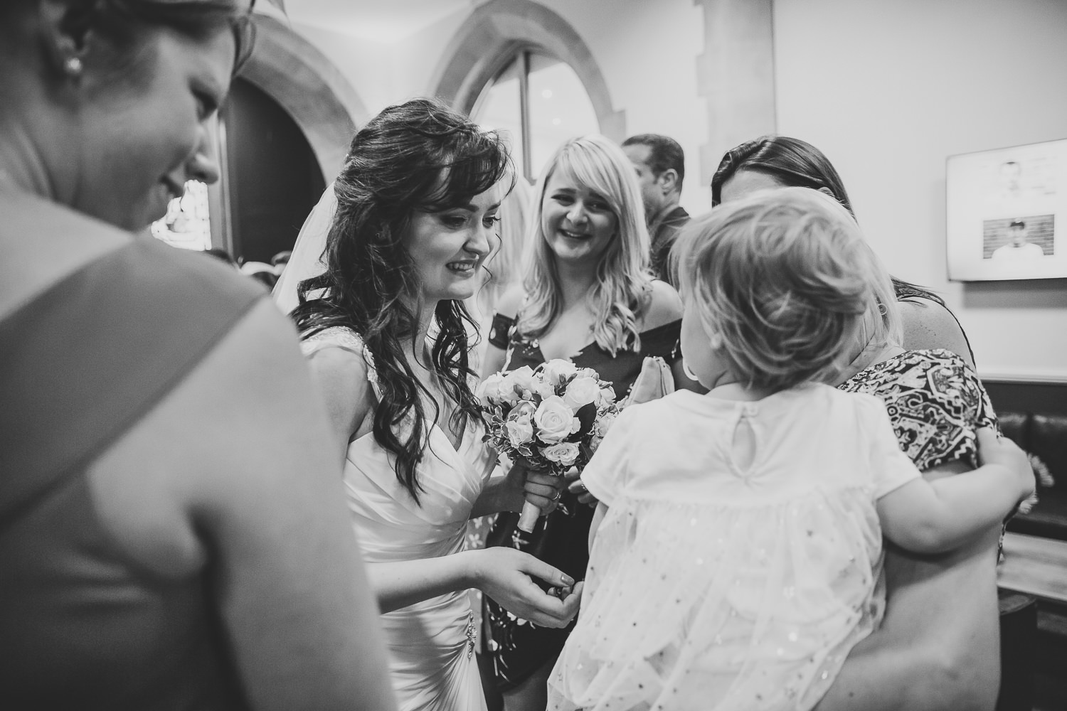 Black and white wedding photography of bride greeting guests after wedding in a London Church