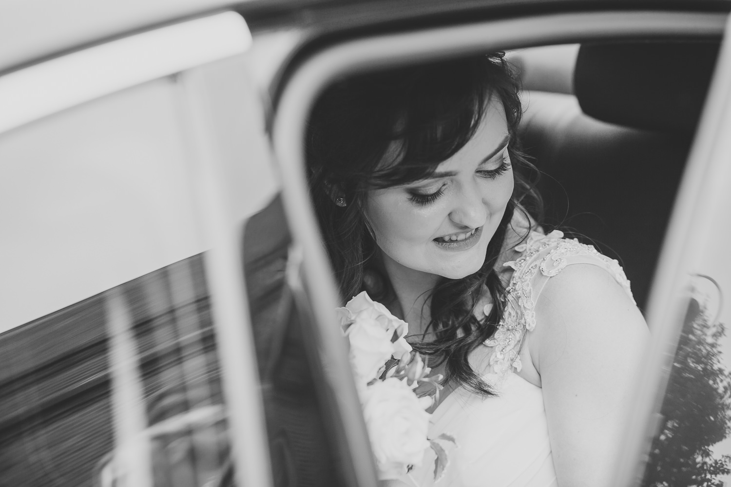 Black and white photo of bride in the wedding car.