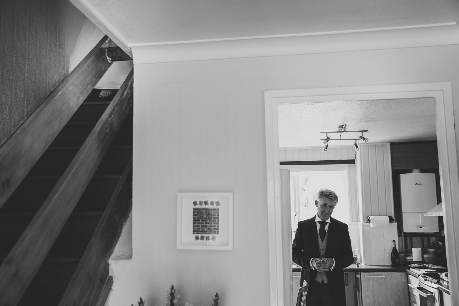 Black and white wedding photo of father of bride waiting to greet the bride