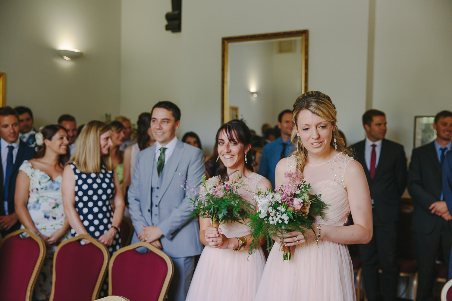 Bridesmaids wearing pink dresses arriving for the wedding inside Ely Registry Office photographed by an Ely Wedding Photographer