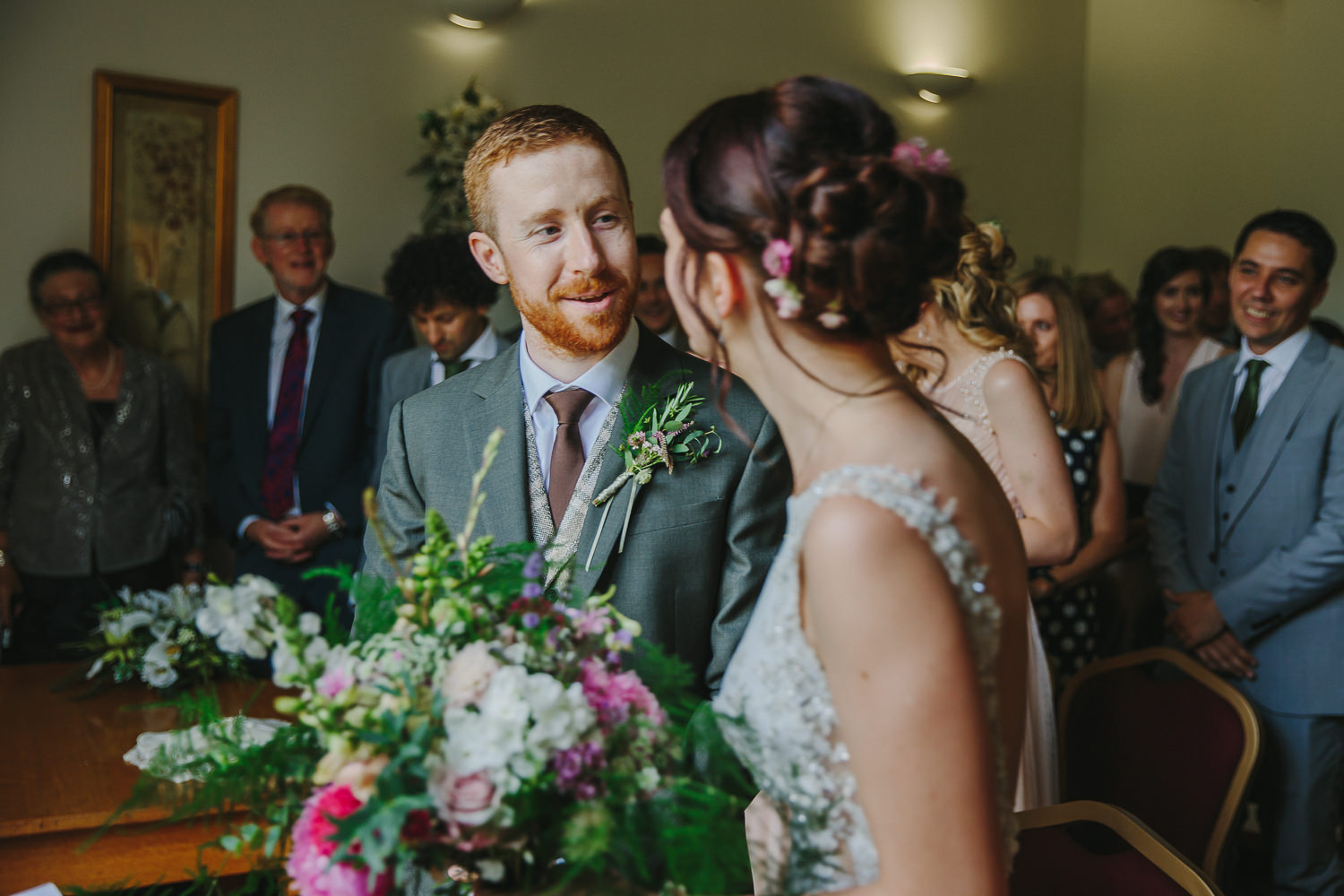 Groom greeting bride before the start of the wedding ceremony inside Ely Registry office, photographed by an Ely Wedding Photographer
