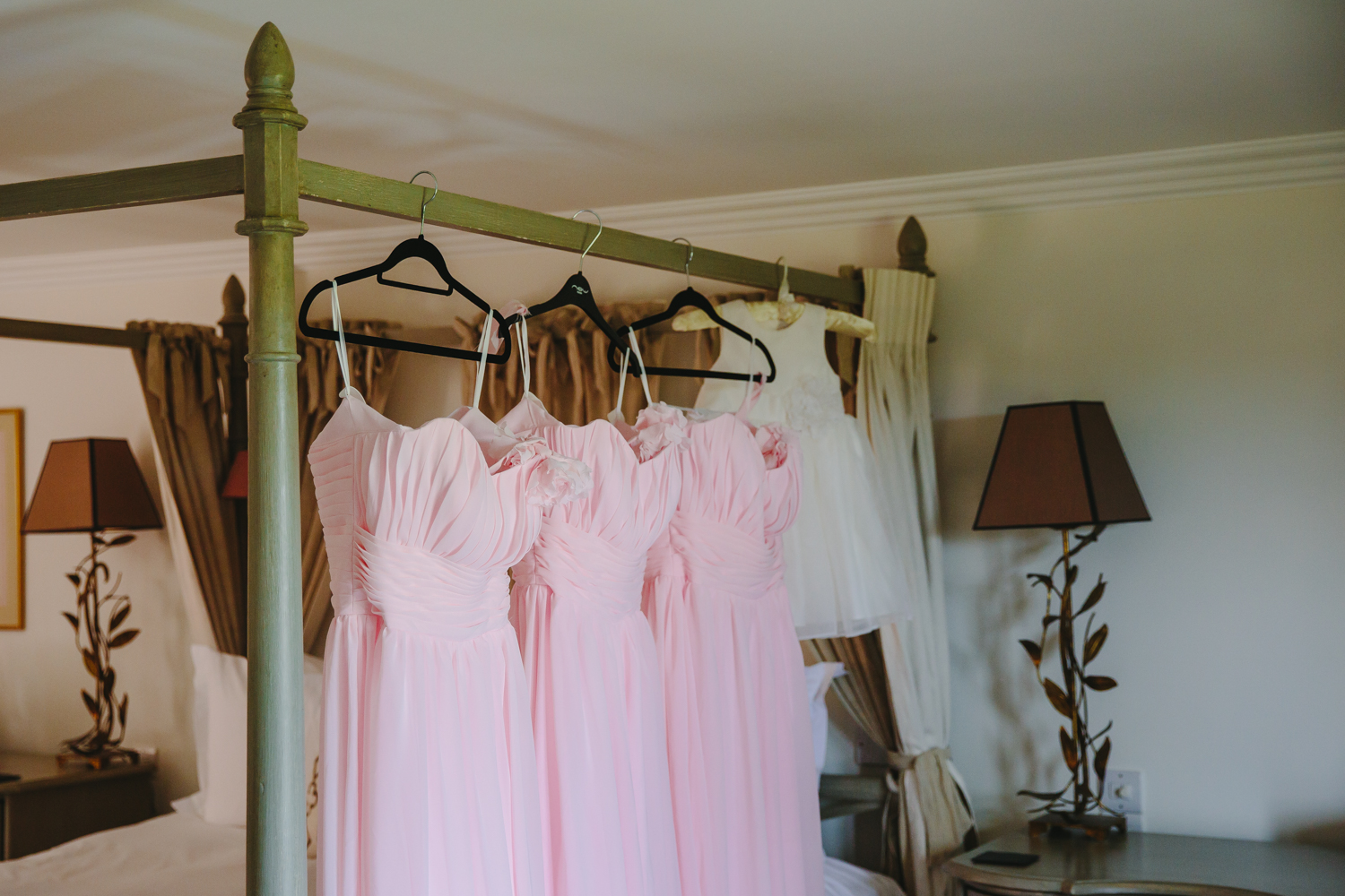 Bridemaids dresses hanging on a bed at The Old Hall Ely.