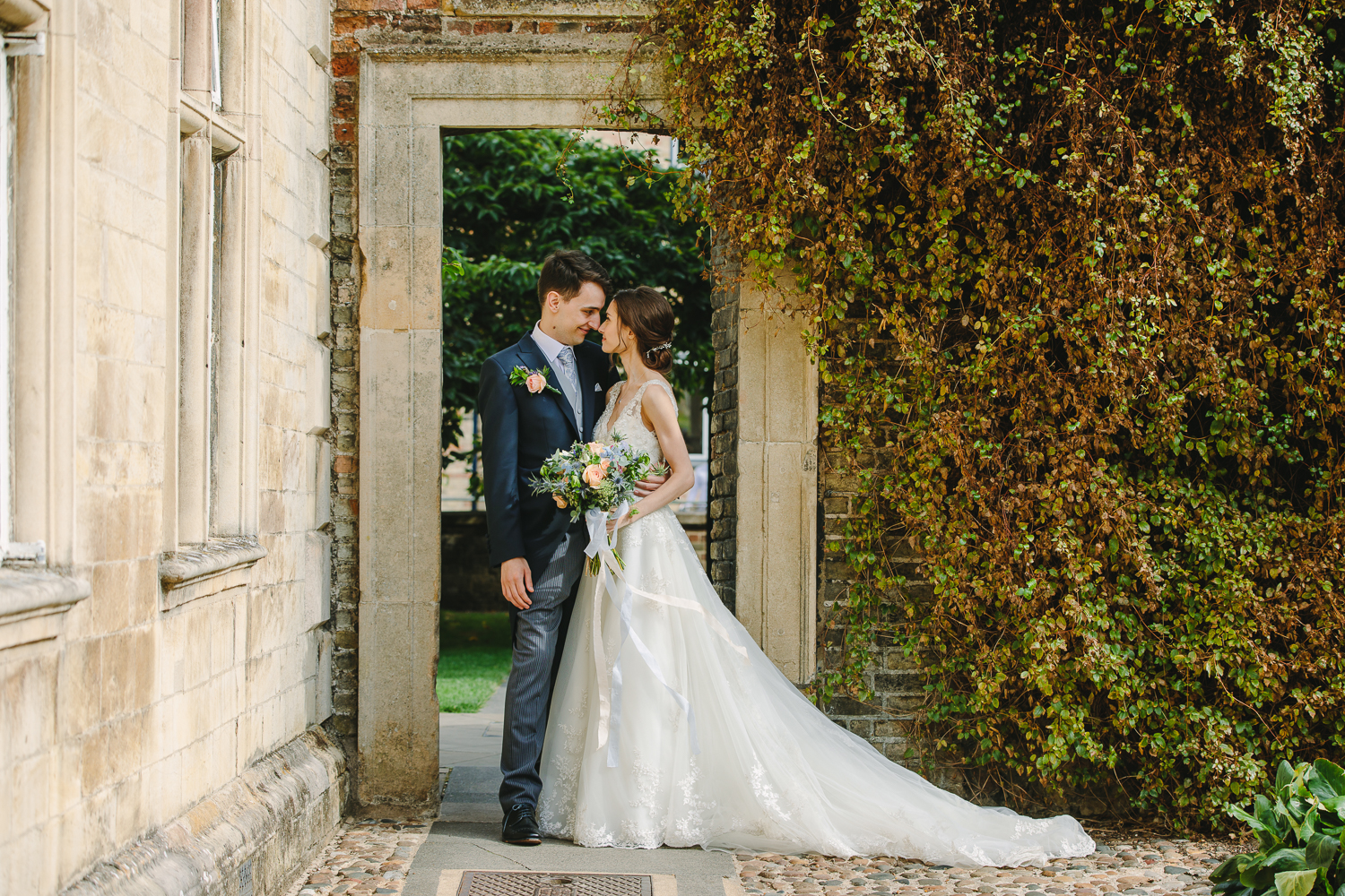 Bride and groom portrait in an archway at Magdalene College Cambridge University