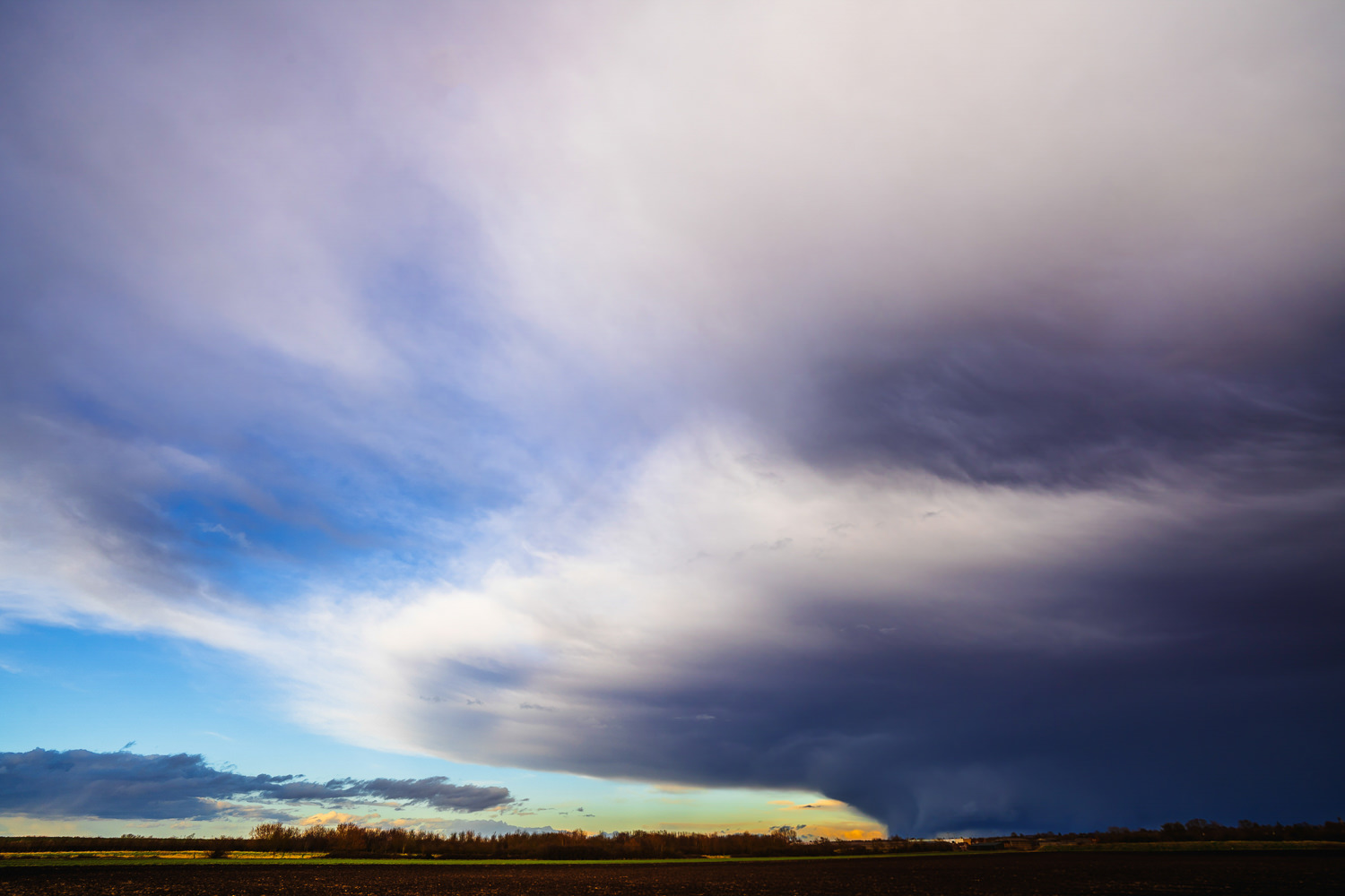 A field and a massive storm cloud